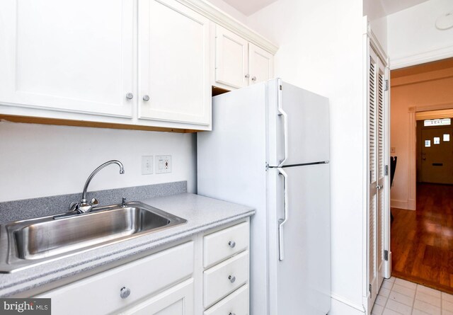 1432 C St SE, Washington, DC 20003 - kitchen with freestanding refrigerator, white cabinetry, and light countertops