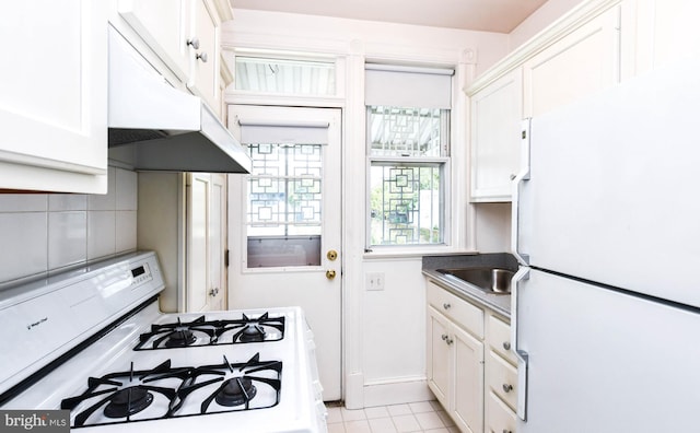 1432 C St SE, Washington, DC 20003 - kitchen with white appliances, under cabinet range hood, white cabinets, and light tile patterned floors