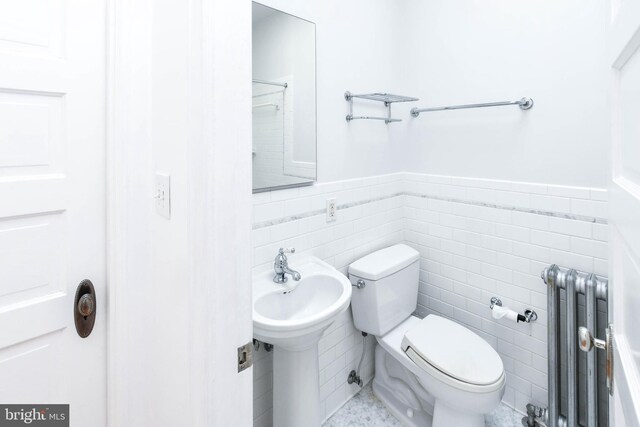 1432 C St SE, Washington, DC 20003 - bathroom with radiator, a wainscoted wall, and tile walls