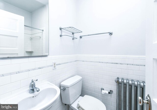 1432 C St SE, Washington, DC 20003 - bathroom featuring radiator, tile walls, a wainscoted wall, and a shower