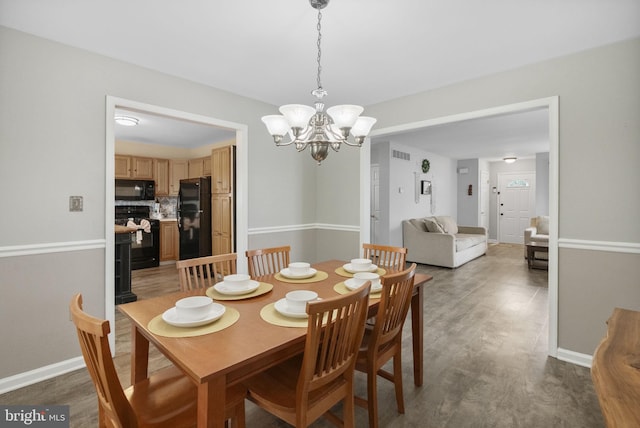 583 Upland St, Pottstown, PA 19464 - dining space featuring a chandelier, wood finished floors, and baseboards