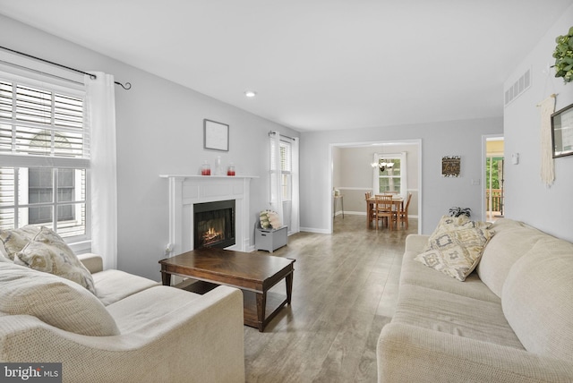 583 Upland St, Pottstown, PA 19464 - living area with light wood-style floors, a chandelier, a warm lit fireplace, recessed lighting, and baseboards