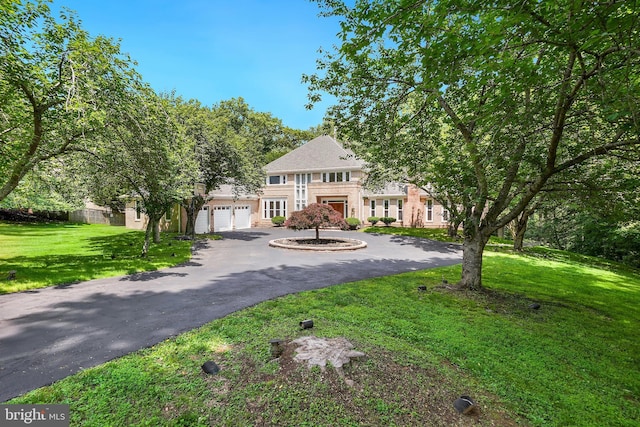 12213 Lake Potomac Ter, Potomac, MD 20854 - colonial-style house featuring curved driveway, a front yard, and an attached garage