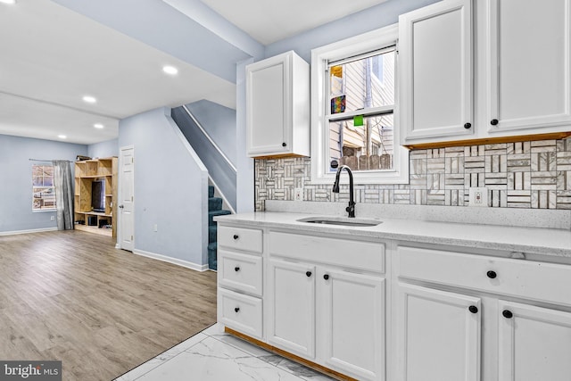 3559 4th St, Baltimore, MD 21225 - kitchen with a sink, white cabinetry, baseboards, decorative backsplash, and light stone countertops