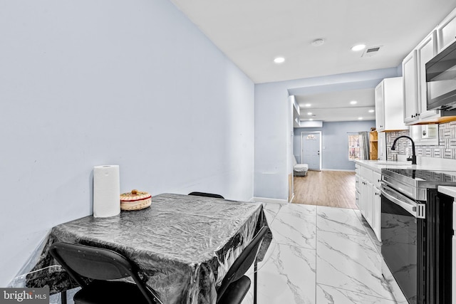 3559 4th St, Baltimore, MD 21225 - dining room featuring recessed lighting, light marble finish flooring, and baseboards