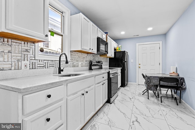 3559 4th St, Baltimore, MD 21225 - kitchen featuring black appliances, a sink, baseboards, white cabinets, and tasteful backsplash