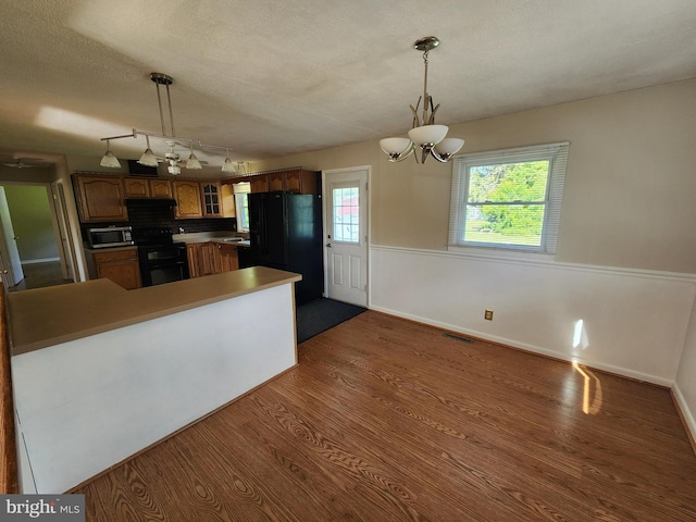 1983 Nault Rd, Dover, DE 19904 - kitchen with black appliances, dark wood finished floors, a chandelier, glass insert cabinets, and pendant lighting