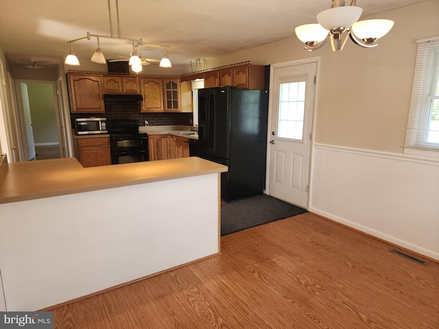 1983 Nault Rd, Dover, DE 19904 - kitchen featuring black appliances, brown cabinetry, extractor fan, and glass insert cabinets