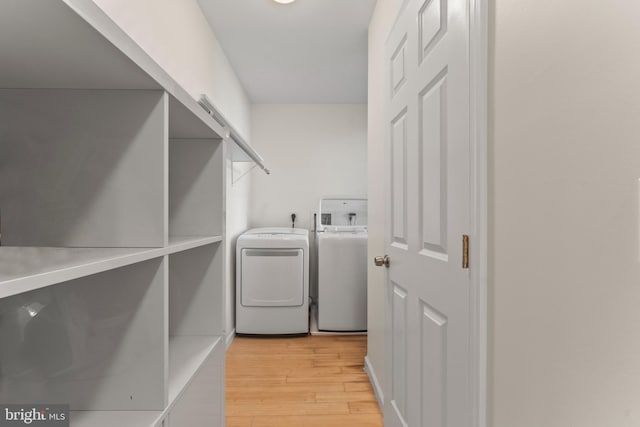 5012 Catalpha Rd, Baltimore, MD 21214 - laundry area with washer and clothes dryer and light wood-style flooring