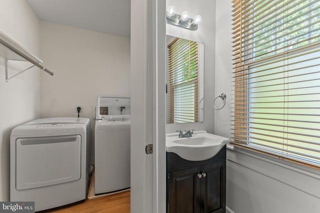 5012 Catalpha Rd, Baltimore, MD 21214 - washroom with washer and clothes dryer, plenty of natural light, and light wood-style floors
