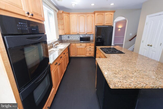 14714 Mount Calvert Rd, Upper Marlboro, MD 20772 - kitchen featuring black appliances, arched walkways, a sink, a kitchen island, and light brown cabinetry