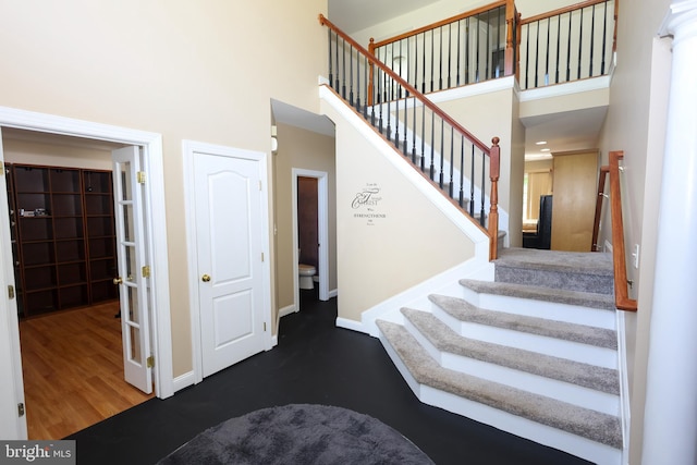 14714 Mount Calvert Rd, Upper Marlboro, MD 20772 - stairway featuring a high ceiling, baseboards, and wood finished floors