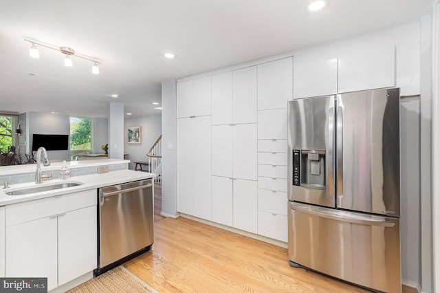 1690 Chimney House Rd, Reston, VA 20190 - kitchen with appliances with stainless steel finishes, light wood-style flooring, white cabinetry, light countertops, and recessed lighting