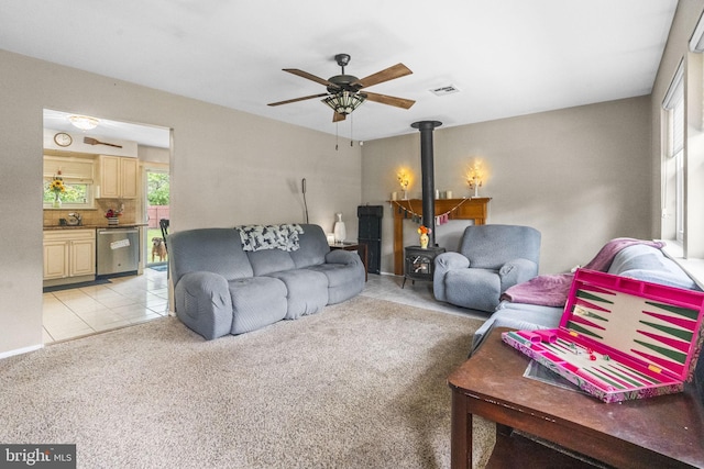 54 Tecumseh Trl, Browns Mills, NJ 08015 - living area featuring a wood stove, ceiling fan, light carpet, and light tile patterned floors