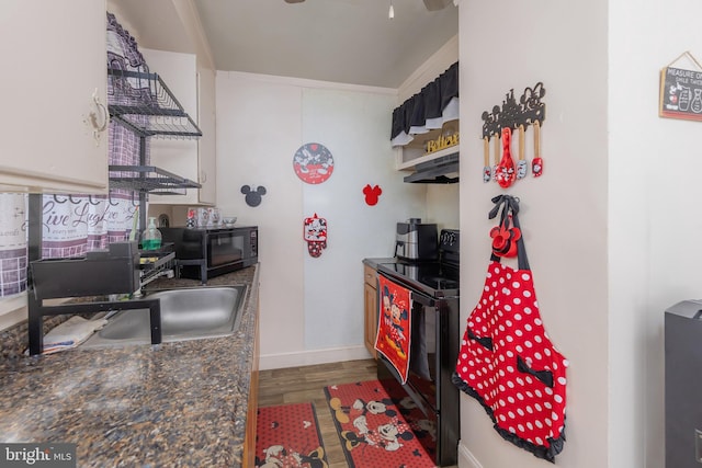 724 S W Ave, Vineland, NJ 08360 - kitchen with black appliances, under cabinet range hood, dark wood-style flooring, a sink, and baseboards