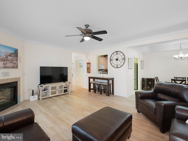 30619 Cedar Neck Rd Unit 1101, Ocean View, DE 19970 - living room with crown molding, light wood-style floors, a chandelier, a tiled fireplace, and a ceiling fan