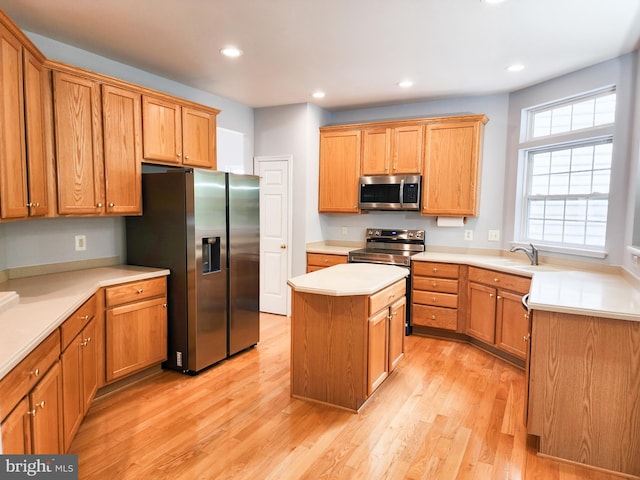 9120 Stonegarden Dr, Lorton, VA 22079 - kitchen with appliances with stainless steel finishes, a center island, light wood-style floors, recessed lighting, and light countertops