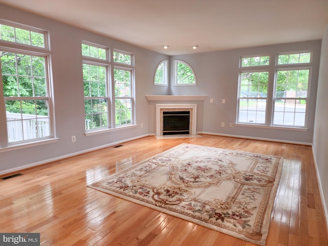 9120 Stonegarden Dr, Lorton, VA 22079 - unfurnished living room featuring baseboards, hardwood / wood-style flooring, and a fireplace with flush hearth