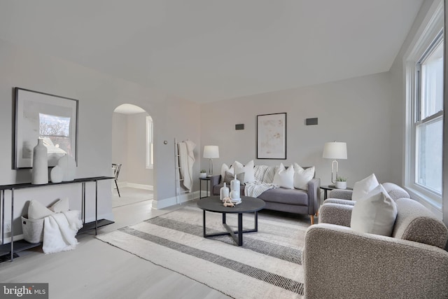 518 Fairview Ave, Baltimore, MD 21224 - living room featuring arched walkways, light wood-style flooring, and baseboards
