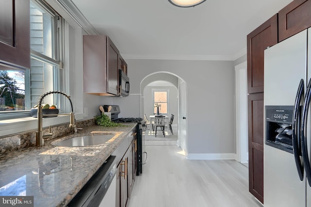 518 Fairview Ave, Baltimore, MD 21224 - kitchen featuring stainless steel appliances, arched walkways, a sink, crown molding, and light wood-style flooring