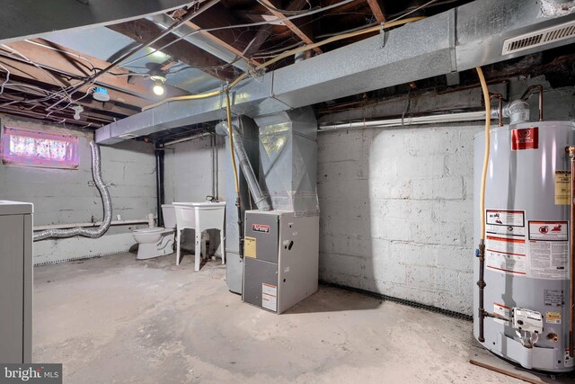 518 Fairview Ave, Baltimore, MD 21224 - below grade area with gas water heater, heating unit, washer / clothes dryer, and a sink