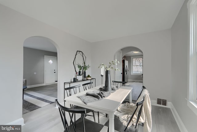 518 Fairview Ave, Baltimore, MD 21224 - dining room featuring arched walkways, light wood-style flooring, and baseboards