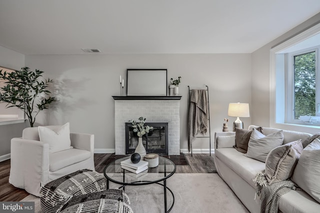 6505 Corkley Rd, Baltimore, MD 21237 - living room with wood finished floors, a brick fireplace, and baseboards