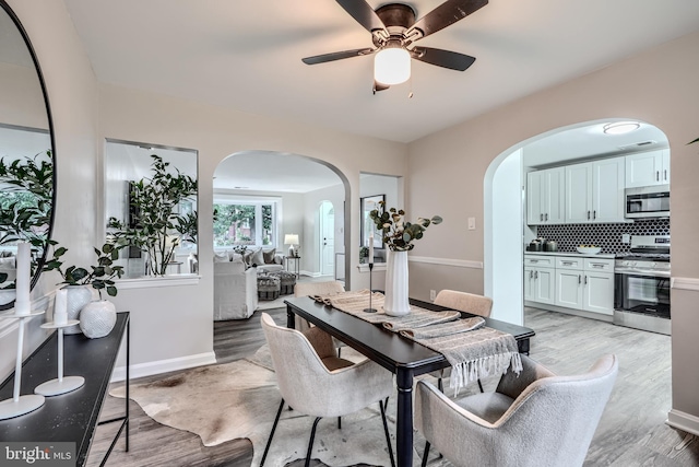 6505 Corkley Rd, Baltimore, MD 21237 - dining space with arched walkways, light wood-type flooring, ceiling fan, and baseboards
