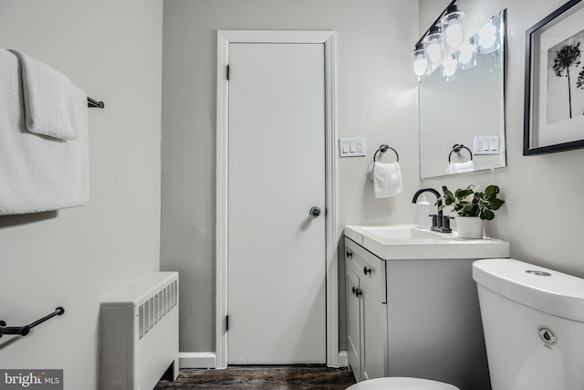 6505 Corkley Rd, Baltimore, MD 21237 - half bathroom featuring toilet, vanity, radiator, and wood finished floors