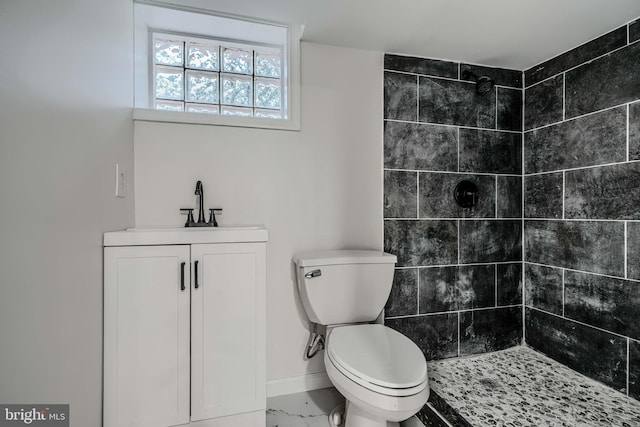 6505 Corkley Rd, Baltimore, MD 21237 - bathroom featuring a tile shower, toilet, marble finish floors, baseboards, and vanity