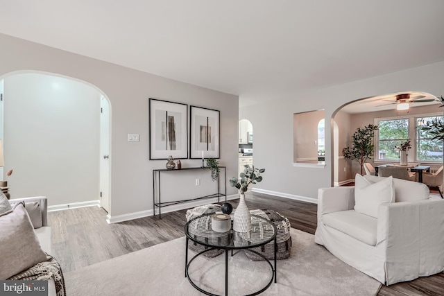 6505 Corkley Rd, Baltimore, MD 21237 - living room featuring arched walkways, wood finished floors, a ceiling fan, and baseboards