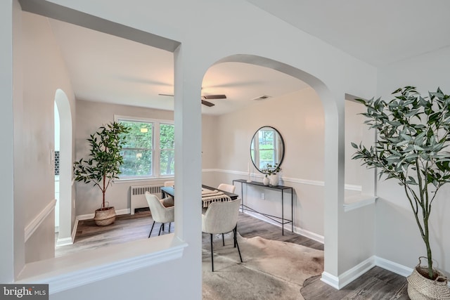 6505 Corkley Rd, Baltimore, MD 21237 - dining space with radiator heating unit, wood finished floors, a ceiling fan, and arched walkways