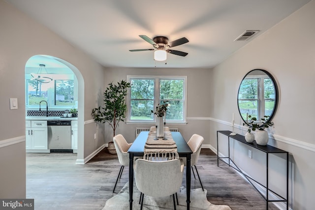 6505 Corkley Rd, Baltimore, MD 21237 - dining room with a ceiling fan, light wood-style floors, arched walkways, and baseboards