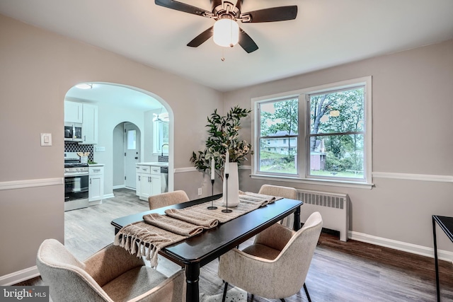 6505 Corkley Rd, Baltimore, MD 21237 - dining space with radiator heating unit, arched walkways, a ceiling fan, and healthy amount of natural light
