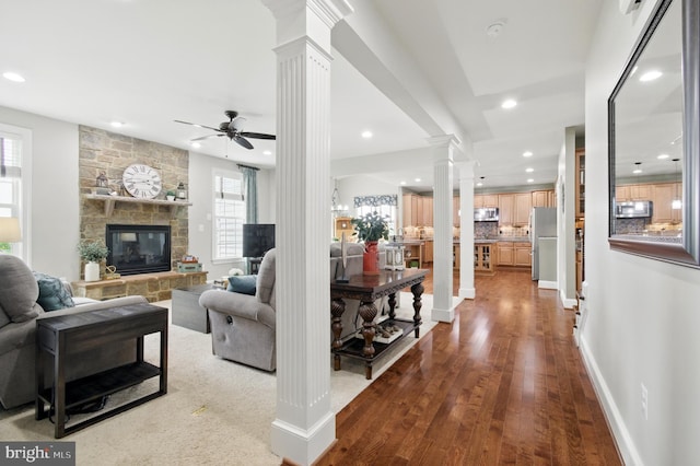 14894 Michele Dr, Glenelg, MD 21737 - living area with ornate columns, recessed lighting, wood finished floors, a fireplace, and a ceiling fan