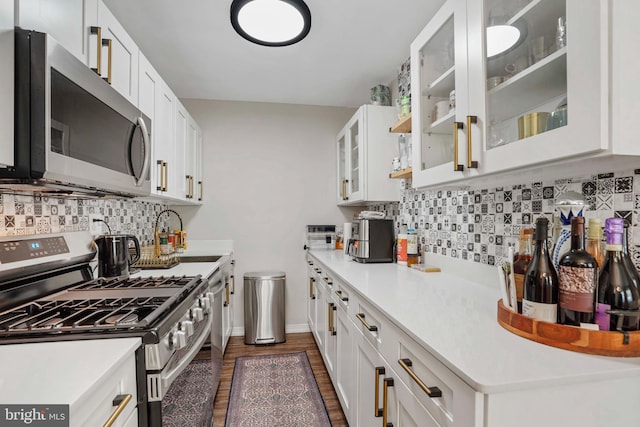 1200 S Arlington Ridge Rd Unit 314, Arlington, VA 22202 - kitchen with appliances with stainless steel finishes, a sink, decorative backsplash, dark wood finished floors, and white cabinetry