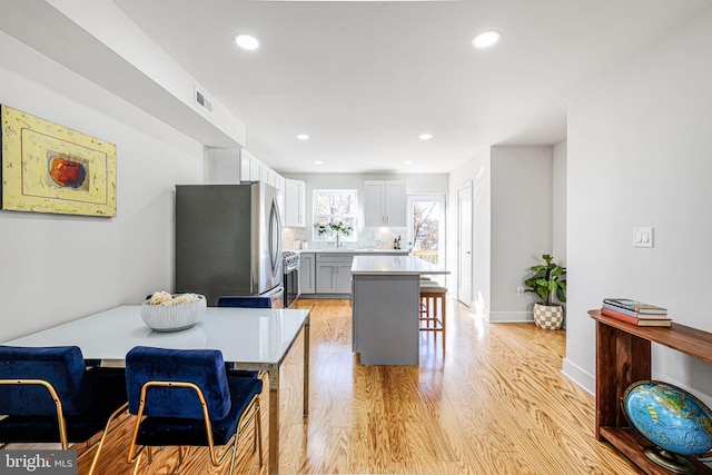 2220 13th St NE, Washington, DC 20018 - kitchen with freestanding refrigerator, a breakfast bar, light wood-style floors, light countertops, and tasteful backsplash