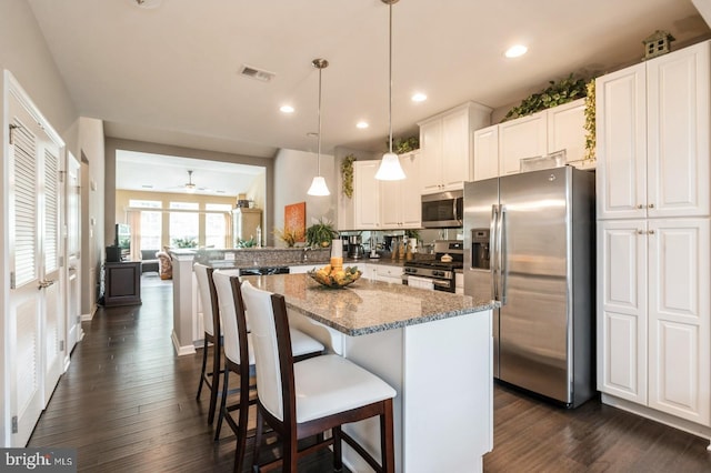 44 Heals Farm Rd, Burlington, NJ 08016 - kitchen featuring appliances with stainless steel finishes, dark wood-style floors, light stone countertops, white cabinets, and a kitchen island