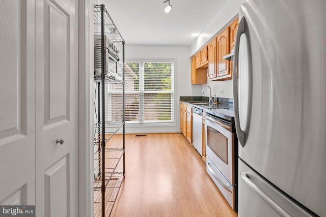 2932 Winters Chase Way, Annapolis, MD 21401 - kitchen featuring appliances with stainless steel finishes, dark countertops, a sink, light wood finished floors, and under cabinet range hood