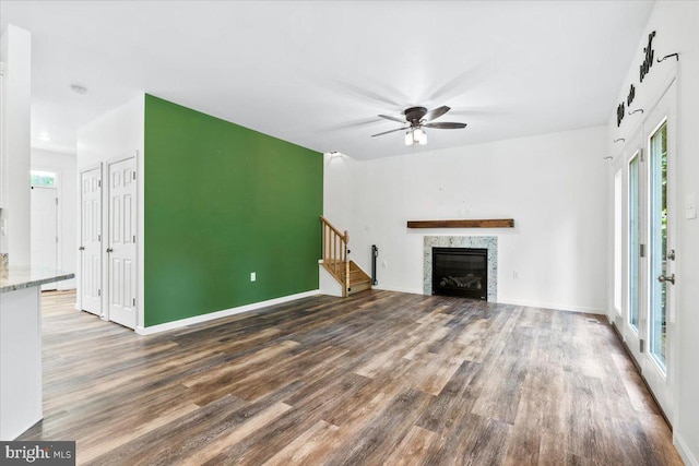 163 Hyde Park Ln, Charles Town, WV 25414 - unfurnished living room with wood finished floors, ceiling fan, baseboards, and a glass covered fireplace