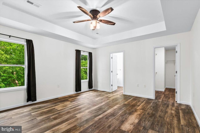 163 Hyde Park Ln, Charles Town, WV 25414 - unfurnished bedroom featuring wood finished floors, a walk in closet, baseboards, a raised ceiling, and a ceiling fan