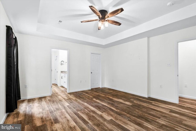 163 Hyde Park Ln, Charles Town, WV 25414 - unfurnished bedroom featuring a raised ceiling, wood finished floors, baseboards, and ensuite bath