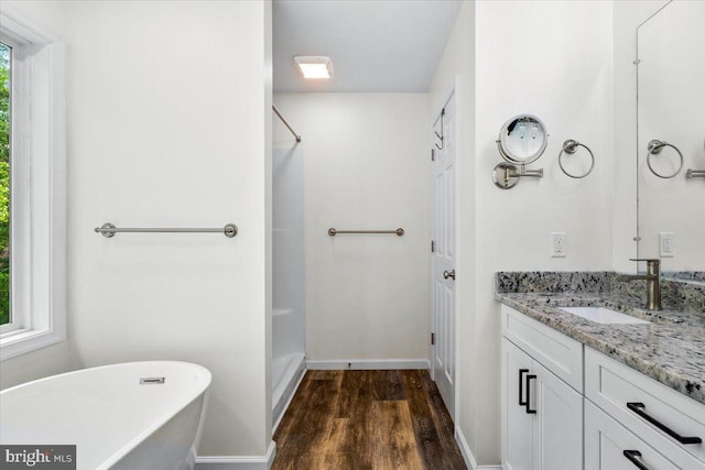 163 Hyde Park Ln, Charles Town, WV 25414 - full bath with wood finished floors, vanity, a freestanding tub, a shower, and baseboards