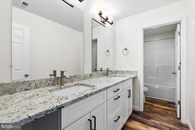 163 Hyde Park Ln, Charles Town, WV 25414 - bathroom with toilet, double vanity, wood finished floors, and shower / bathtub combination