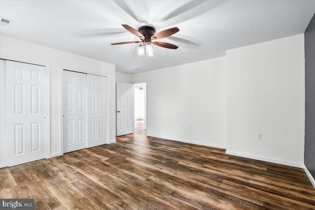 163 Hyde Park Ln, Charles Town, WV 25414 - unfurnished bedroom with multiple closets, dark wood-style floors, baseboards, and ceiling fan