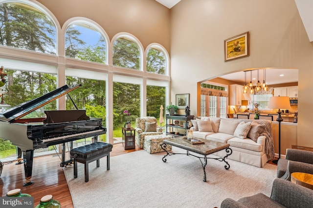 18403 Rim Rock Cir, Leesburg, VA 20176 - living room with a towering ceiling, a chandelier, wood finished floors, and plenty of natural light