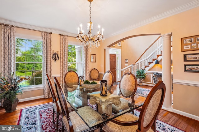 18403 Rim Rock Cir, Leesburg, VA 20176 - dining space with hardwood / wood-style floors, a chandelier, arched walkways, baseboards, and crown molding
