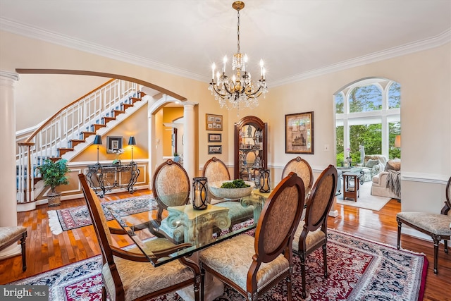 18403 Rim Rock Cir, Leesburg, VA 20176 - dining room with decorative columns, crown molding, arched walkways, stairs, and wood finished floors