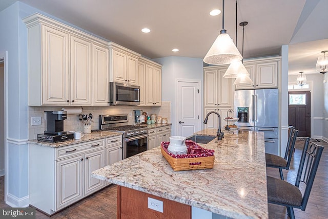24440 Harvest Cir, Milton, DE 19968 - kitchen featuring premium appliances, a kitchen breakfast bar, a sink, light stone counters, and baseboards