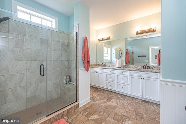 24440 Harvest Cir, Milton, DE 19968 - bathroom featuring a shower stall, double vanity, and a wainscoted wall